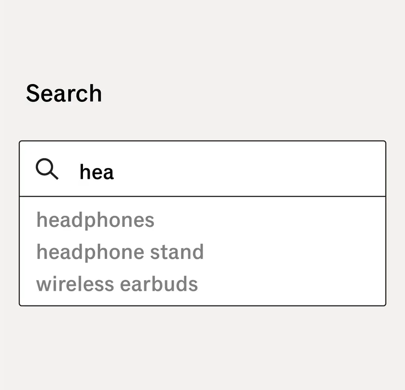 Search bar interface showing autocomplete functionality. As the user types “hea” into the search field, a dropdown appears with suggested search terms: “headphones,” “headphone stand,” and “wireless earbuds.” This demonstrates a flexible, user-friendly design that supports faster and more accurate searching through real-time predictive suggestions.