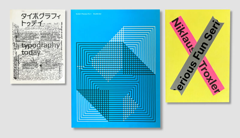 Overhead view of three design books: a Japanese typography book, a cyan book and a yellow book with a pink and gray label.