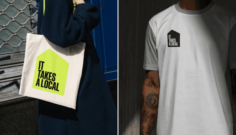 It Takes A Local merch, including a branded tote bag and t-shirt